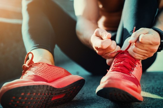 Adolescente atando cordones de las deportivas