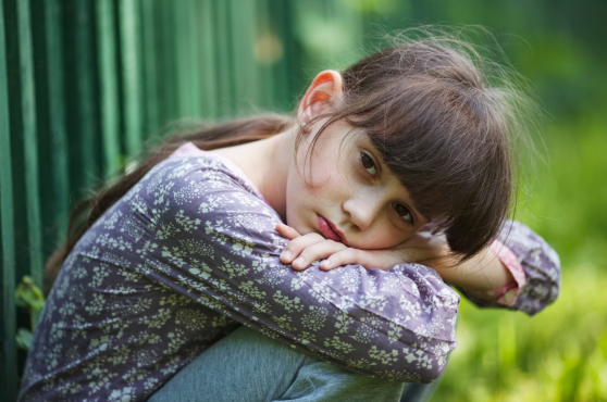 Niña en actitud melancólica