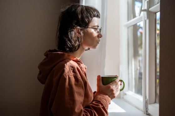 Chica TEA mirando por la ventana.