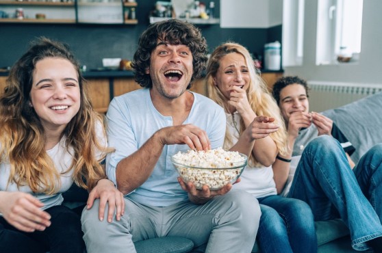 Familia mirando peli en el sofá.