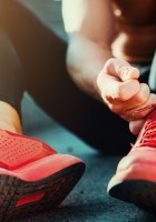 Adolescente atando cordones de las deportivas